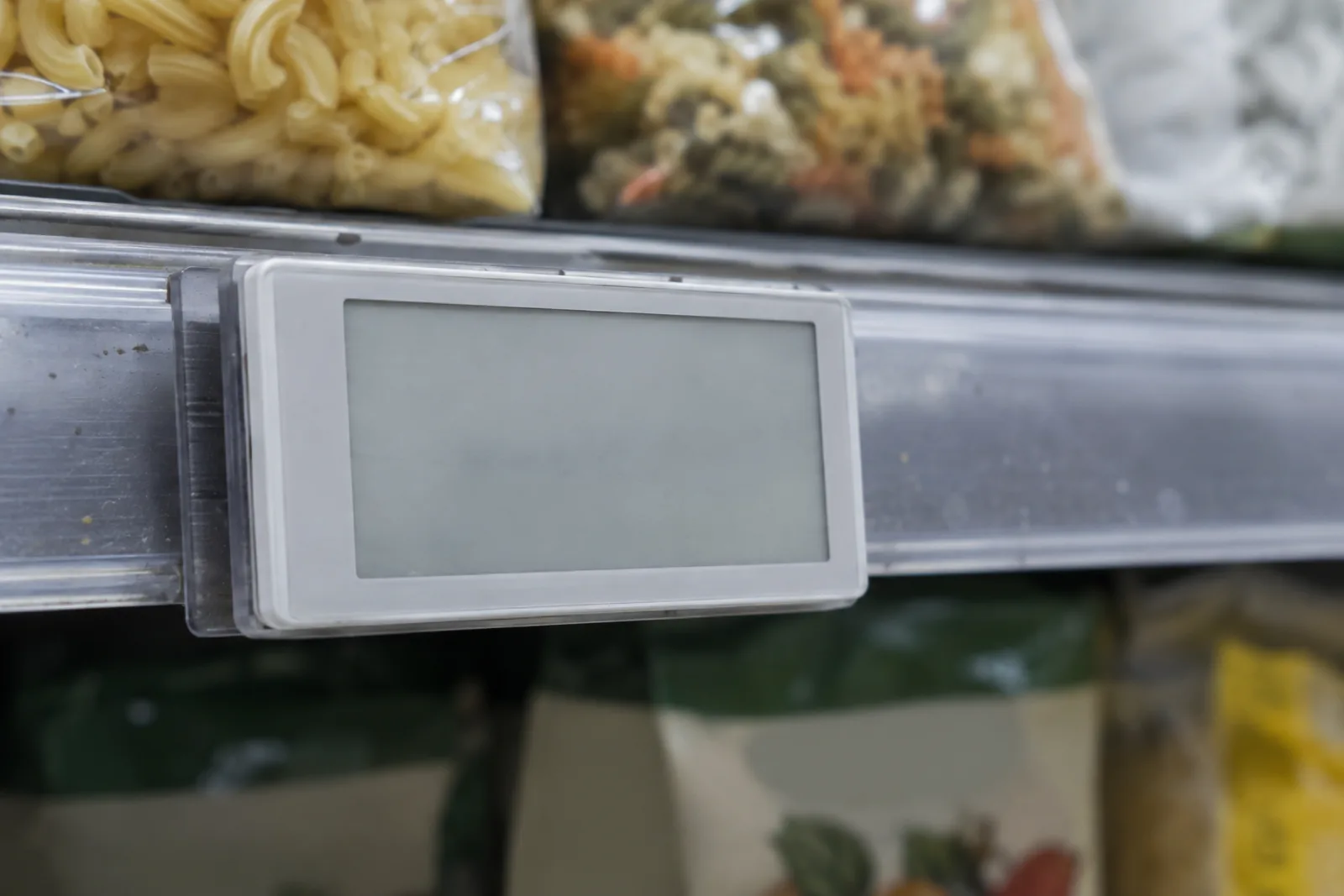 Närbild av en elektronisk hyllkantsetikett fäst på en butikshylla
