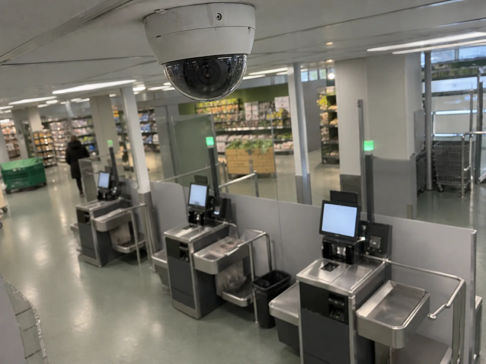 Övervakningskamera monterad i taket ovanför ett självbetjäningsområde i en butik
